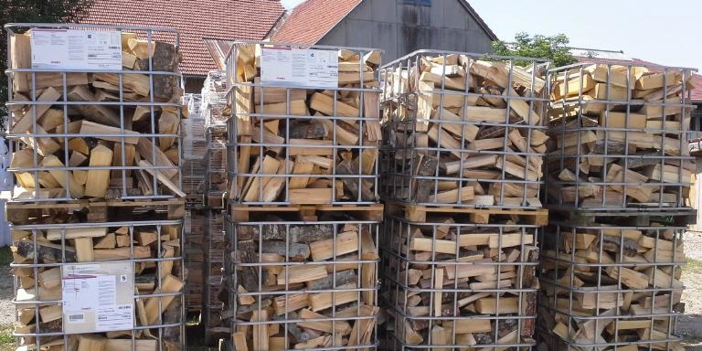 Gestapelte Brennholzscheite in Lagerboxen